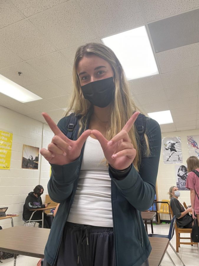 Ansley Tanner, Senior, is show holding up a “W” in support of bringing Winning Wednesdays back to Roswell High School // Photo Creds: Grace Swift