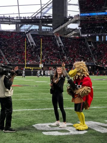 Katie Northenor standing with Atlanta Falcons mascot.