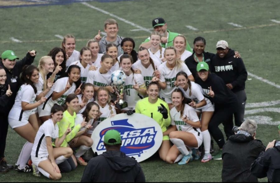 The+girls+posing+with+their+team+and+coaching+staff+as+well+as+the+newest+addition+to+Roswell+High+School%E2%80%99s+trophy+case.+%28Credit%3A+Carolyn+Saker%29