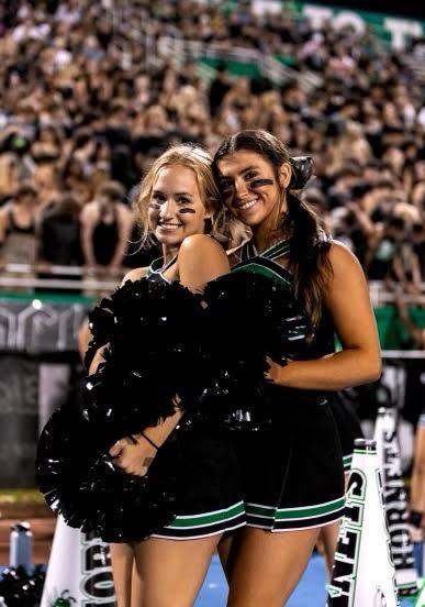Cheer captains, seniors, Brinley Dye and Caroline Jenacova cheering at the blackout game on Sep. 8. spending quality enjoying the moment of the event. (Credit: Billy Clouse)