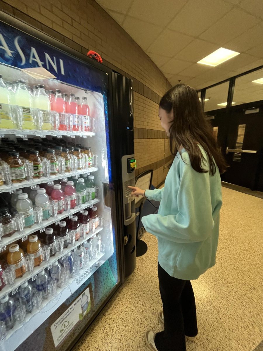 Freshman Abby Carter purchases a drink during A lunch from the cafeterias Dasani vending machine. (Credit: Karlie Zabrocki)