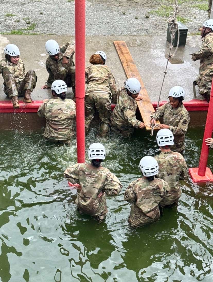 The JROTC cadets moving a plank of wood to use for their reconstruction project.